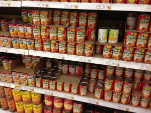 Assortment of Chef Boyardee products in the canned goods aisle in a typical grocery store.